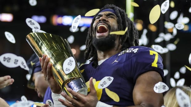 Michigan running back Donovan Edwards (7) picks up the trophy to celebrate 34-13 win over Washington at the national championship game at NRG Stadium in Houston on Monday, Jan. 8, 2024.
